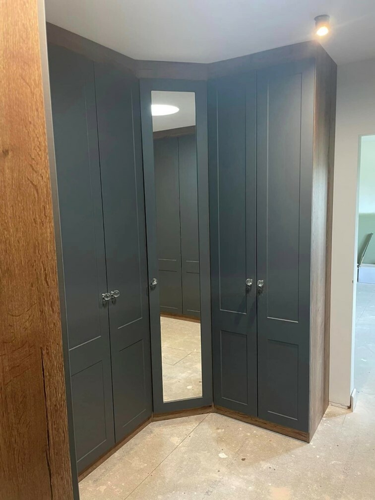 Bespoke fitted wardrobe with mirrored corner panel.