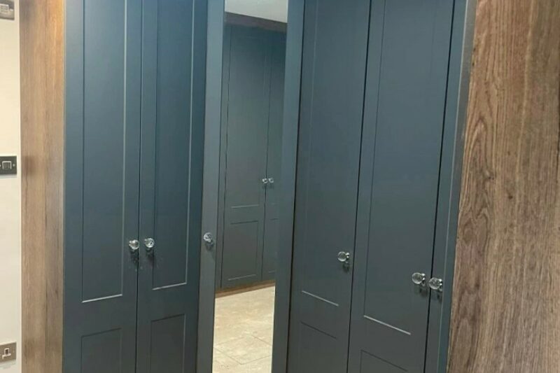 Bespoke fitted wardrobe with angled corner panel finished in Kombu green.